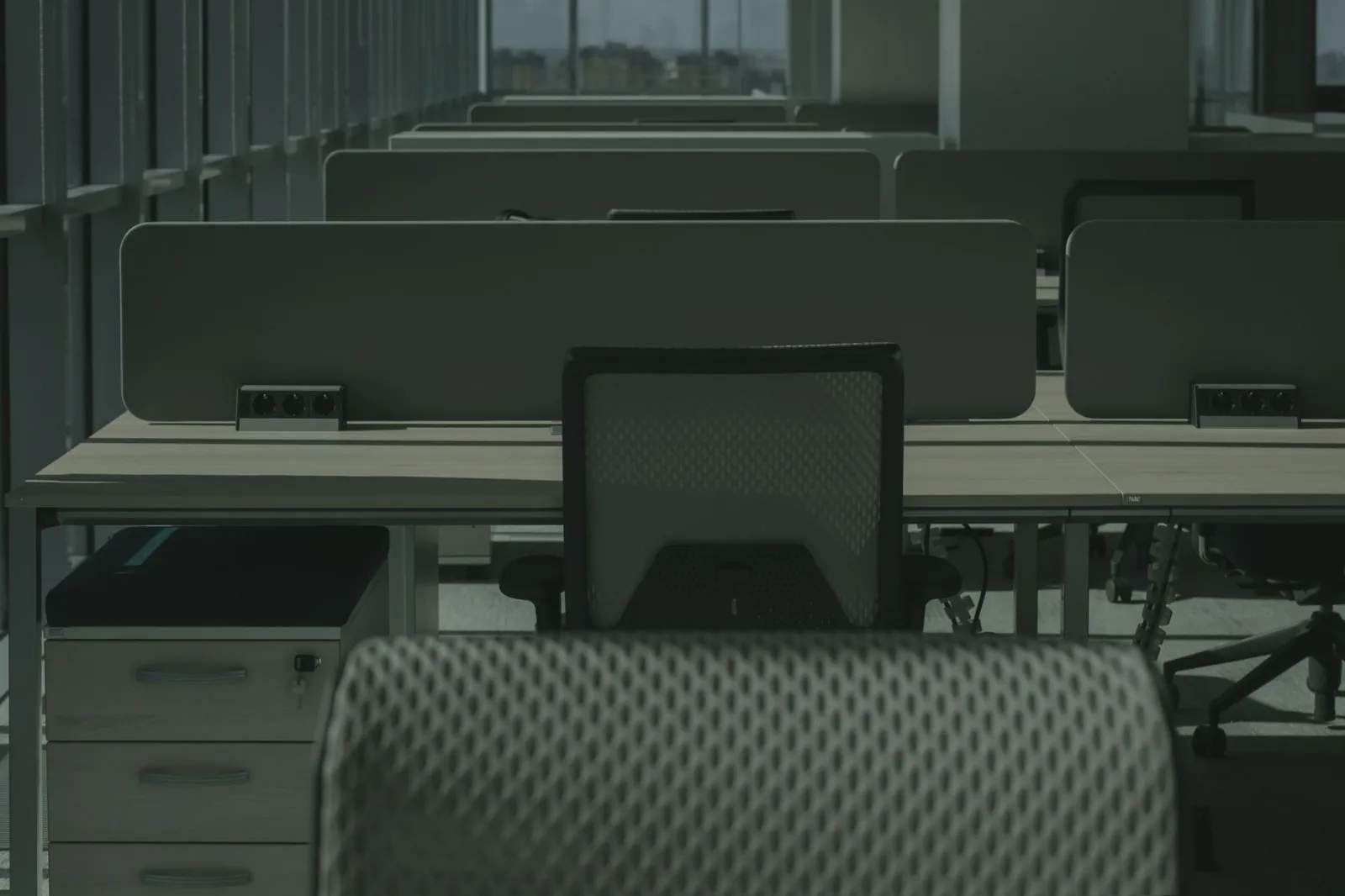 A sleek modern office with multiple desks and chairs, showcasing an empty and orderly workspace.